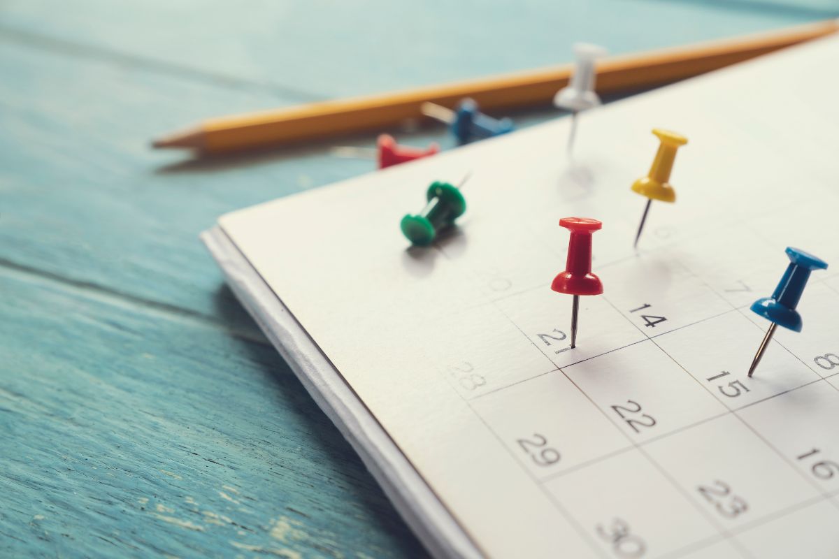 Calendar with push pins marking weekend dates for North Aurora IL open houses and local home tours
